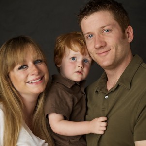 happy portrait of a couple and their young red headed son